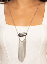 Load image into Gallery viewer, A fringe of silver chains swings from the bottom of a wooden frame adorned with a shimmery silver feather charm. Dotted with an earthy Military Olive stone, the whimsical pendant attaches to a lengthened silver chain for a free-spirited finish. Features an adjustable clasp closure.  Sold as one individual necklace. Includes one pair of matching earrings.  Always nickel and lead free.