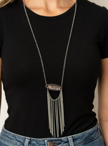 A fringe of silver chains swings from the bottom of a wooden frame adorned with a shimmery silver feather charm. Dotted with a refreshing orange stone, the whimsical pendant attaches to a lengthened silver chain for a free-spirited finish. Features an adjustable clasp closure.  Sold as one individual necklace. Includes one pair of matching earrings.  Always nickel and lead free.