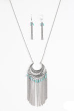 Load image into Gallery viewer, Etched in geometric patterns, a silver crescent swings from the bottom of an elongated silver chain. The tribal inspired pendant gives way to a shimmery fringe sprinkled with shiny blue beads for a seasonal finish. Features an adjustable clasp closure.  Sold as one individual necklace. Includes one pair of matching earrings.