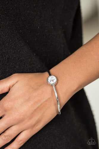 A faceted white gem is pressed into the center of a shimmery silver bangle, creating a dramatic centerpiece atop the wrist.  Sold as one individual bracelet.  Always nickel and lead free.