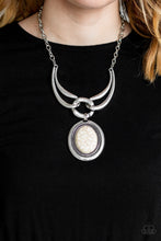 Load image into Gallery viewer, Three handcrafted silver pieces connect below the collar in a bold artisan inspired fashion. Nestled in the center of a studded silver frame, an oversized white stone pendant swings from the bottom of the interlocking frames for a dramatic finish. Features an adjustable clasp closure.  Sold as one individual necklace. Includes one pair of matching earrings.  Always nickel and lead free.