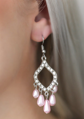 Encrusted in glassy white rhinestones, a shimmery silver frame gives way to a pearly pink fringe for an elegant fashion. Earring attaches to a standard fishhook fitting.  Sold as one pair of earrings.  