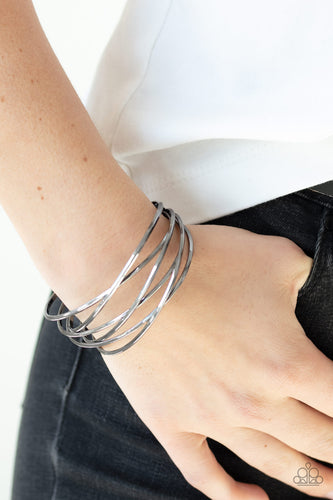 Shiny gunmetal wires crisscross across the wrist, coalescing into an edgy cuff.  Sold as one individual.  Always nickel and lead free.