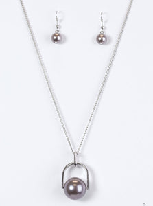 Brushed in a pearlescent shimmer, an oversized gray bead is pinched between a glistening silver frame, creating the illusion of a floating pearl for a dramatic look. Features an adjustable clasp closure.  Sold as one individual necklace. Includes one pair of matching earrings.
