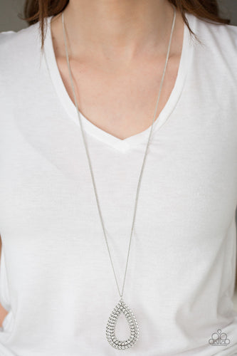 Infused with an elongated silver chain, shimmery chain links spin around a white rhinestone center, creating a dramatic teardrop pendant. Features an adjustable clasp closure.  Sold as one individual necklace. Includes one pair of matching earrings.