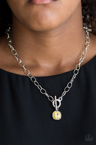 Pressed into a sleek silver frame, a dramatic yellow gem swings from the bottom of a glistening silver chain below the collar for a chic look. Features a toggle closure.  Sold as one individual necklace. Includes one pair of matching earrings.  Always nickel and lead free. 