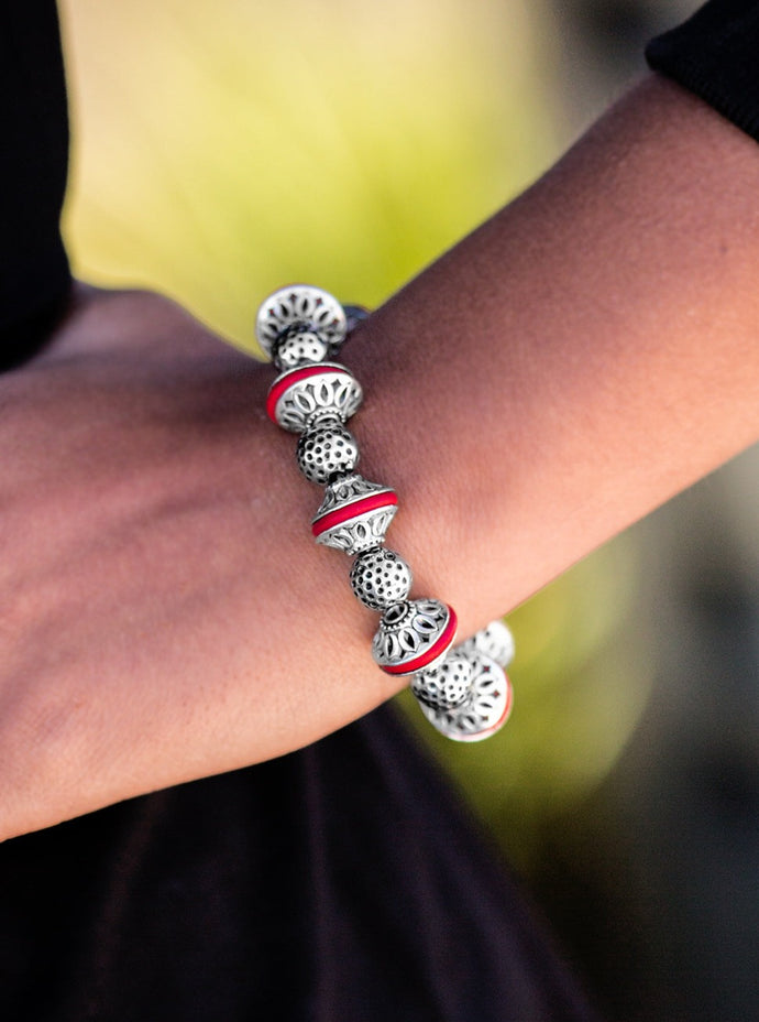 Enchanting silver beads and red stone accents are threaded along a stretchy elastic band, creating a seasonal look around the wrist.  Sold as one individual bracelet. 