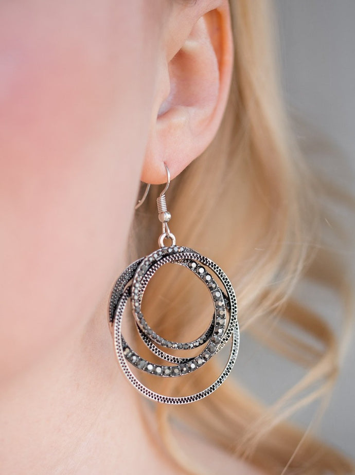 Encrusted in sections of hematite rhinestones, mismatched silver hoops layer into an elegantly entangled lure. Earring attaches to a standard fishhook fitting.  Sold as one pair of earrings.  Always nickel and lead free.