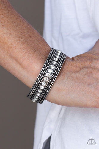 A row of glittery white rhinestones line the center of a studded silver cuff for an edgy look.  Sold as one individual bracelet.  Always nickel and lead free.