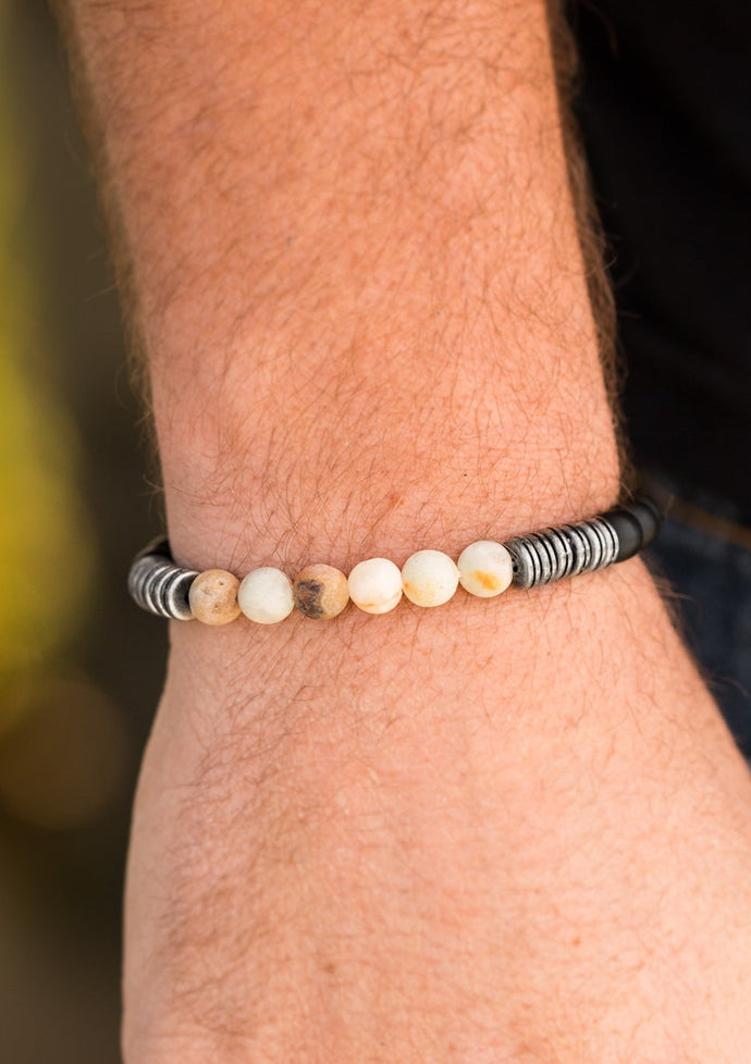 Infused with antiqued metallic accents, smooth black and energetic natural stone beads are threaded along a stretchy elastic band for a seasonal look.  Sold as one individual bracelet.  