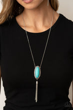 Load image into Gallery viewer, An oval turquoise stone is pressed into a glistening silver frame stamped in antiqued tribal inspired patterns. A shimmery silver chain tassel swings from the bottom of the earthy pendant for a whimsical finish. Features an adjustable clasp closure.  Sold as one individual necklace. Includes one pair of matching earrings. 