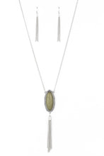 Load image into Gallery viewer, An oval Military Olive stone is pressed into a glistening silver frame stamped in antiqued tribal inspired patterns. A shimmery silver chain tassel swings from the bottom of the earthy pendant for a whimsical finish. Features an adjustable clasp closure.  Sold as one individual necklace. Includes one pair of matching earrings.  