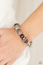 Load image into Gallery viewer, Stamped, studded, and embossed in tribal inspired patterns, a collection of chunky silver beads join earthy wooden beads along a stretchy band around the wrist for an earthy flair.  Sold as one individual bracelet.  Always nickel and lead free.  Fashion Fix Exclusive June 2021