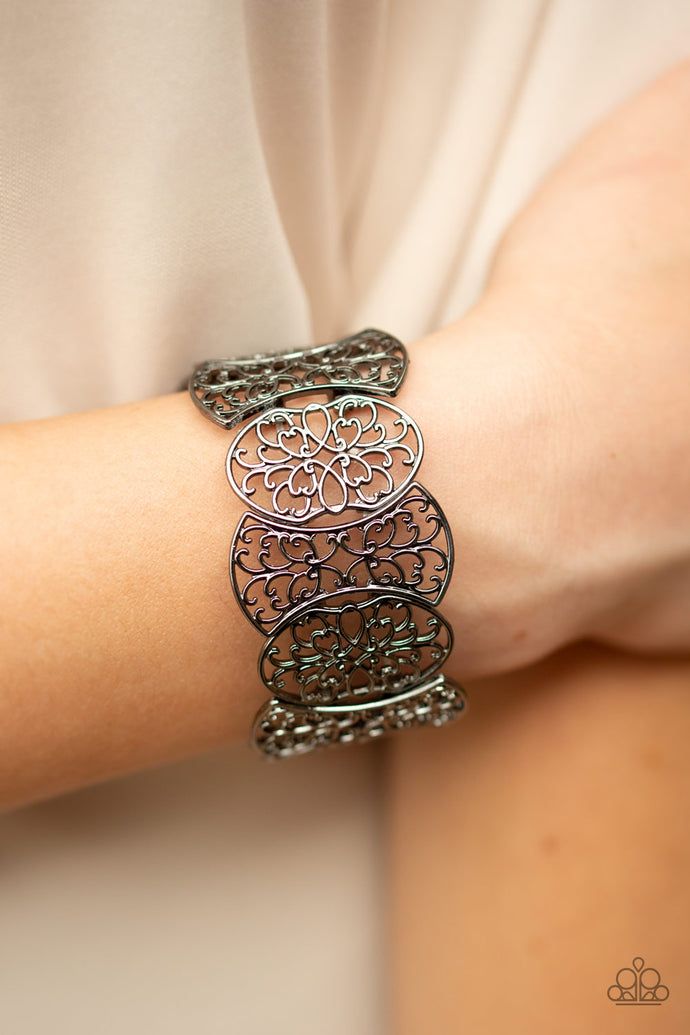 Filled with filigree details, a collection of gunmetal frames are threaded along stretchy bands around the wrist for a whimsical look.  Sold as one individual bracelet.   Always nickel and lead free.