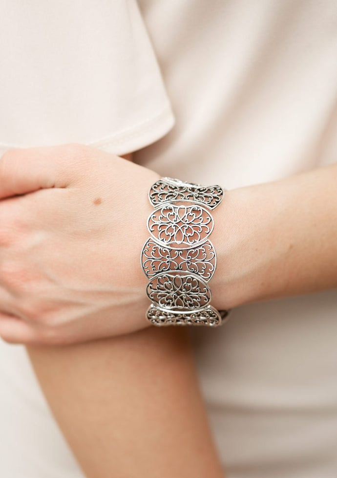 Filled with filigree details, a collection of silver frames are threaded along stretchy bands around the wrist for a whimsical look.  Sold as one individual bracelet.  Always nickel and lead free.
