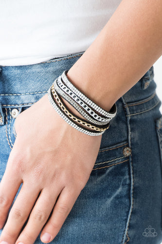 Glassy white and smoky rhinestones are encrusted along strands of black suede. Glistening silver and gold chains are added to the bands, adding edgy industrial shimmer to the sassy palette. Features an adjustable snap closure.  Sold as one individual bracelet.   Always nickel and lead free.