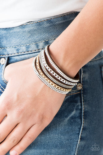 Glassy white and smoky rhinestones are encrusted along strands of brown suede. Glistening silver and gold chains are added to the bands, adding edgy industrial shimmer to the sassy palette. Features an adjustable snap closure.  Sold as one individual bracelet.  Always nickel and lead free.