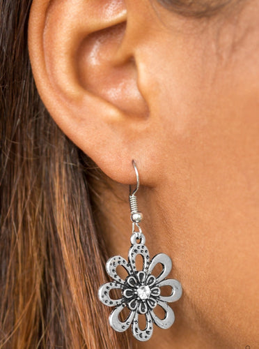 Smooth and hammered silver petals bloom from a radiant white rhinestone center, creating a whimsical frame. Earring attaches to a standard fishhook fitting.  Sold as one pair of earrings.  