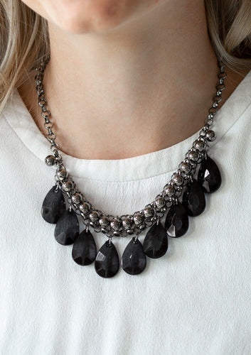 A row of glistening gunmetal beads gives way to glassy black teardrops, creating a bold tone on tone fringe below the collar. Features an adjustable clasp closure.  Sold as one individual necklace. Includes one pair of matching earrings.   