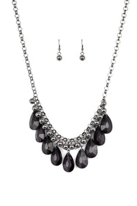 A row of glistening gunmetal beads gives way to glassy black teardrops, creating a bold tone on tone fringe below the collar. Features an adjustable clasp closure.  Sold as one individual necklace. Includes one pair of matching earrings.   