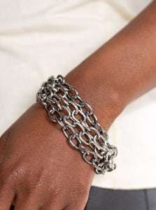 Four strands of bold gunmetal and silver chain layer across the wrist for an edgy look. Features an adjustable clasp closure.  Sold as one individual bracelet.