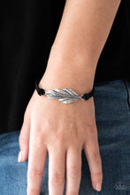 Load image into Gallery viewer, Strands of black suede knot around a shimmery silver feather charm, creating a seasonal pendant atop the wrist. Features an adjustable clasp closure.  Sold as one individual bracelet.  Always nickel and lead free.