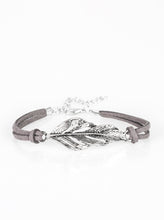 Load image into Gallery viewer, Strands of gray suede knot around a shimmery silver feather charm, creating a seasonal pendant atop the wrist. Features an adjustable clasp closure.  Sold as one individual bracelet. 