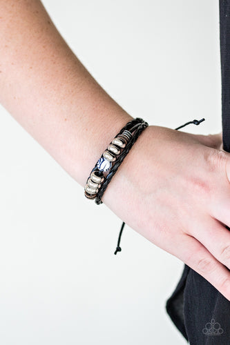 Mismatched black leather bands layer across the wrist. Infused with mixed metallic accents, an ornate bead slides along the center for a seasonal finish. Features an adjustable sliding knot closure.  Sold as one individual bracelet.  Always nickel and lead free.