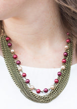 Load image into Gallery viewer, A strand of classic colorful pearls gives way to layers of mismatched brass chain, creating a fierce look below the collar. Features an adjustable clasp closure.  Sold as one individual necklace. Includes one pair of matching earrings.