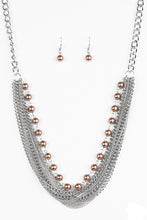 Load image into Gallery viewer, A strand of classic brown pearls gives way to layers of mismatched silver chain, creating a fierce look below the collar. Features an adjustable clasp closure.  Sold as one individual necklace. Includes one pair of matching earrings.
