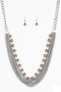 A strand of classic brown pearls gives way to layers of mismatched silver chain, creating a fierce look below the collar. Features an adjustable clasp closure.  Sold as one individual necklace. Includes one pair of matching earrings.