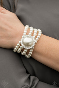 Threaded along stretchy bands, four strands of pearly white beads are held in place by an exaggerated pearl bead encased in a frame of glassy white rhinestones for a vintage-inspired finish. 
