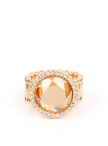 An oversized champagne gem is bordered by traditional white rhinestones. The heirloom-esque presence gives a nod to grandmother's jewelry box as it catches the eye and requests a second look. Features a stretchy band for a flexible fit.