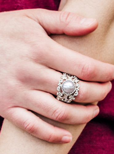 A pearly silver bead is pressed into a frilly filigree band swirling with dotted textures for a refined look. Features a stretchy band for a flexible fit.  Sold as one individual ring.