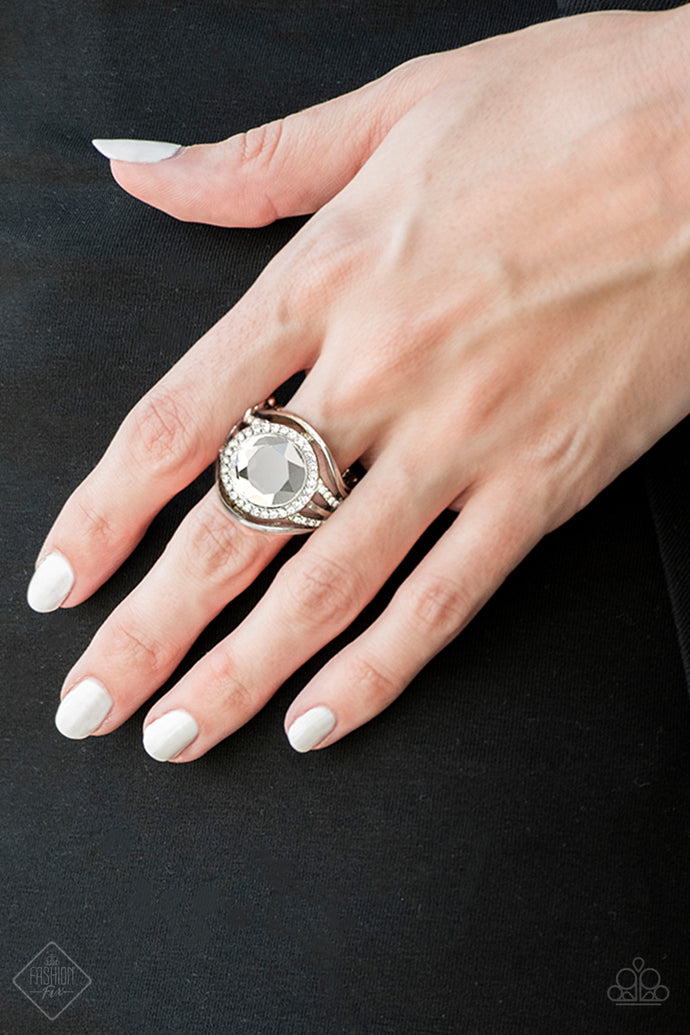Bands of silver alternating with rows of sparkling rhinestones build towards a dramatically over-sized glassy white gem that demands attention. Features a stretchy band for a flexible fit.   Sold as one individual ring