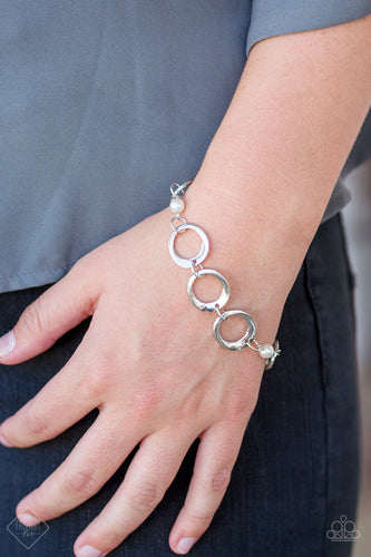 ﻿Asymmetrical silver hoops connect with pearly white beads across the wrist for a refined look. Features an adjustable clasp closure.  Sold as one individual bracelet.  Always nickel and lead free.
