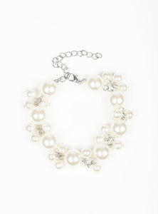 Infused with clusters of dainty white pearls, oversized pearls link around the wrist, creating a bubbly fringe. Features an adjustable clasp closure.  Sold as one individual bracelet.