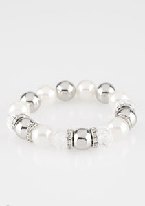 Over-sized silver, crystal-like, and pearly white beads are threaded along a stretchy elastic band and wrapped around the wrist for a glamorous look. White rhinestone encrusted rings are sprinkled between the dramatic beads for a sparkling finish.  Sold as one individual bracelet.