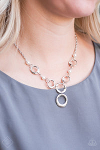 Asymmetrical silver hoops connect with pearly white beads below the collar for a refined look. Features an adjustable clasp closure.