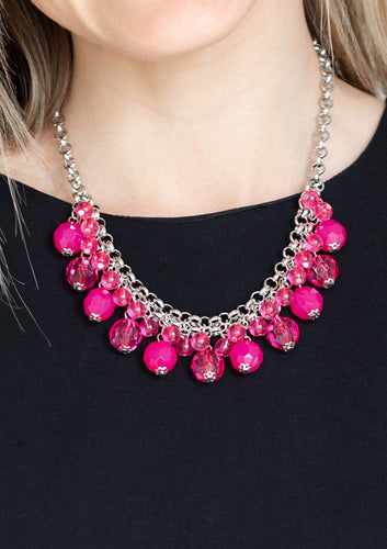 A collection of glassy and opaque pink crystal-like beads swing from the bottom of interlocking silver chains, creating a fabulous fringe below the collar. Features an adjustable clasp closure.  Sold as one individual necklace. Includes one pair of matching earrings. 