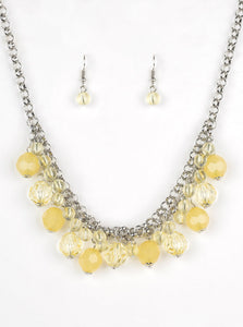 A collection of glassy and opaque yellow crystal-like beads swing from the bottom of interlocking silver chains, creating a fabulous fringe below the collar. Features an adjustable clasp closure.  Sold as one individual necklace. Includes one pair of matching earrings.