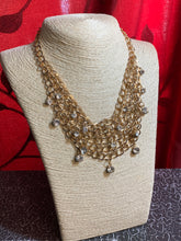 Load image into Gallery viewer, A collar of layered interlocking gold chain provides the canvas for gorgeous clear rhinestones to sway delicately. Features an adjustable clasp closure.  Sold as one individual necklace. includes one pair of marching earrings.  
