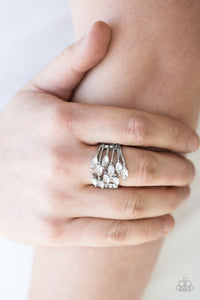 Featuring regal marquise style cuts, glassy white rhinestones attach at the ends of dainty silver bars. The glittery gems collect at the center, creating a glamorous centerpiece atop the finger. Features a stretchy band for a flexible fit.  Sold as one individual ring.   Always nickel and lead free.