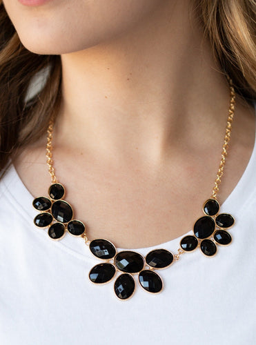 Gradually increasing in size near the center, a collection of black beaded gold frames link into a gorgeous statement piece. Featuring a faceted finish, the sparkling oval beaded frames fan out below the collar for a refined flair. Features an adjustable clasp closure.  Sold as one individual necklace. Includes one pair of matching earrings. 