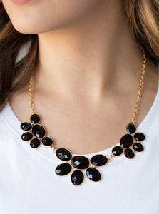 Gradually increasing in size near the center, a collection of black beaded gold frames link into a gorgeous statement piece. Featuring a faceted finish, the sparkling oval beaded frames fan out below the collar for a refined flair. Features an adjustable clasp closure.  Sold as one individual necklace. Includes one pair of matching earrings. 