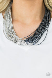 Brushed in a flashy metallic finish, countless strands of blue seed beads converge with strands of silver seed beads, creating colorful layers below the collar. Features an adjustable clasp closure.  Sold as one individual necklace. Includes one pair of matching earrings.  Always nickel and lead free.