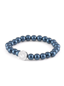 Blue pearls and a white rhinestone encrusted silver charm are threaded along a stretchy band, creating a glamorous centerpiece atop the wrist. Sold as one individual bracelet.