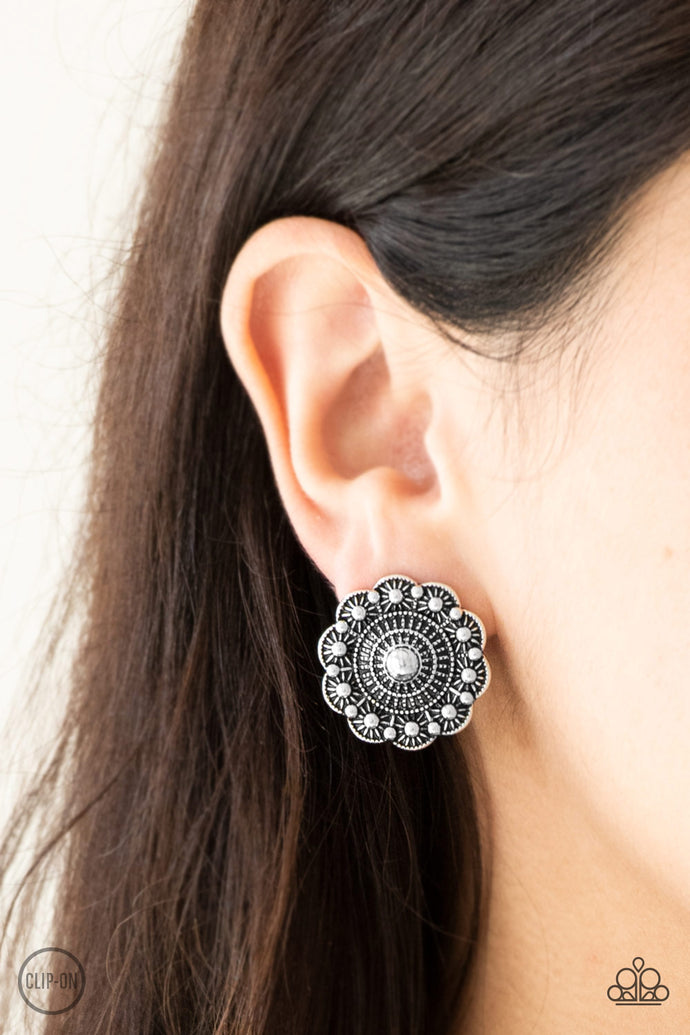 Brushed in an antiqued shimmer, a studded silver floral frame radiates with rippling textures for a seasonal fashion. Earring attaches to a standard clip-on fitting.  Sold as one pair of clip-on earrings.  Always nickel and lead free.