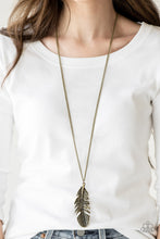 Load image into Gallery viewer, Featuring studded and antiqued textures, a dramatic brass feather pendant swings from the bottom of an elongated brass chain for a free-spirited fashion. Features an adjustable clasp closure.  Sold as one individual necklace. Includes one pair of matching earrings.   Always nickel and lead free.
