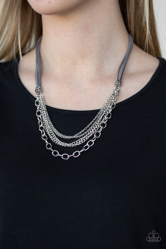 Suspended between strips of earthy gray suede, mismatched strands of silver layer below the collar for a spunky industrial look. Features an adjustable clasp closure.  Sold as one individual necklace. Includes one pair of matching earrings.  Always nickel and lead free